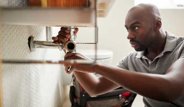 a male plumber fixing a pipe connection from Quality Plumber Leander in Leander, TX Plumber near me